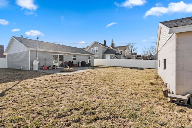 rear view of house with an outdoor fire pit, a patio area, fence, and a lawn