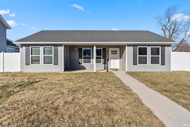 ranch-style house featuring roof with shingles, a front lawn, and fence