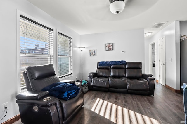 living area with visible vents, baseboards, and wood finished floors