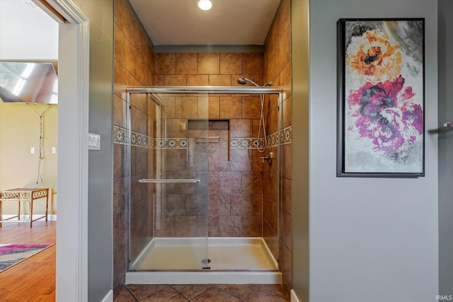 bathroom with baseboards, a shower stall, and tile patterned flooring