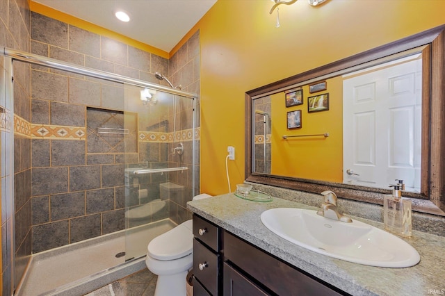 bathroom with tile patterned floors, toilet, a stall shower, recessed lighting, and vanity