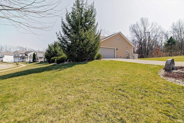 view of yard featuring a garage and concrete driveway