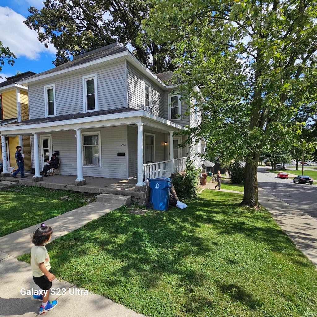 view of front of home featuring covered porch and a front yard