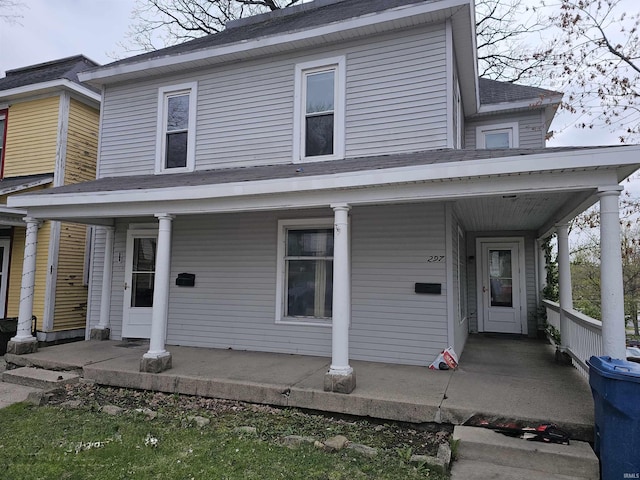 view of front of house featuring covered porch and a shingled roof