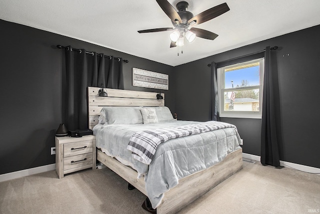 bedroom featuring light carpet, ceiling fan, and baseboards