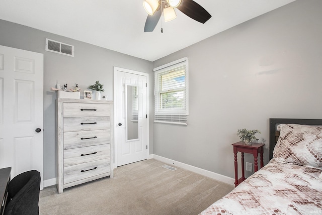 bedroom with ceiling fan, light colored carpet, visible vents, and baseboards