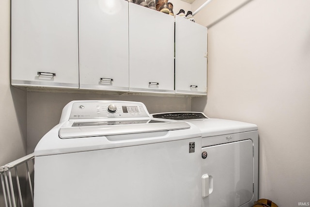 washroom featuring washing machine and dryer and cabinet space