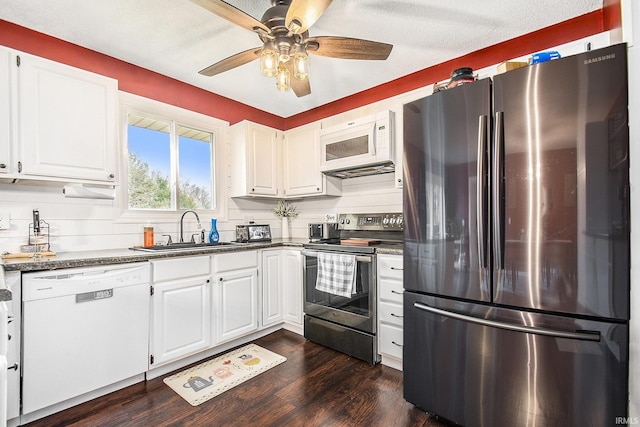 kitchen with a sink, dark wood finished floors, stainless steel appliances, white cabinets, and ceiling fan