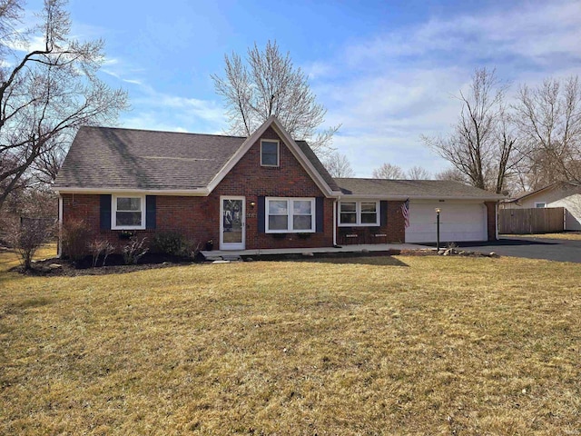 view of front facade with fence, a front lawn, a garage, aphalt driveway, and brick siding