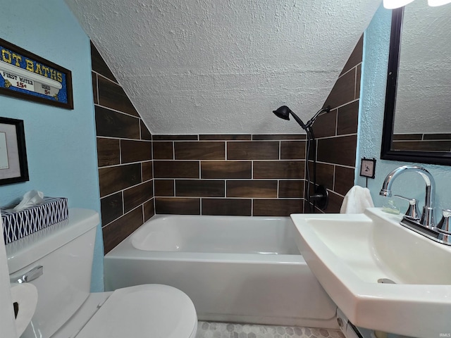 bathroom with a textured ceiling, toilet, a textured wall, and a sink