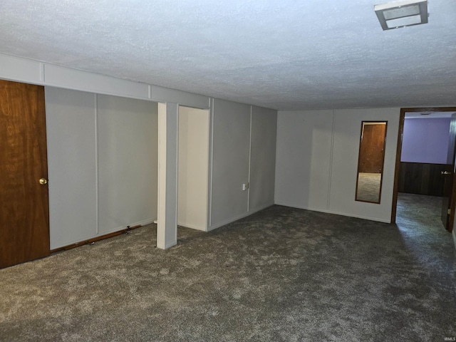 finished basement featuring carpet floors, a textured ceiling, and baseboards