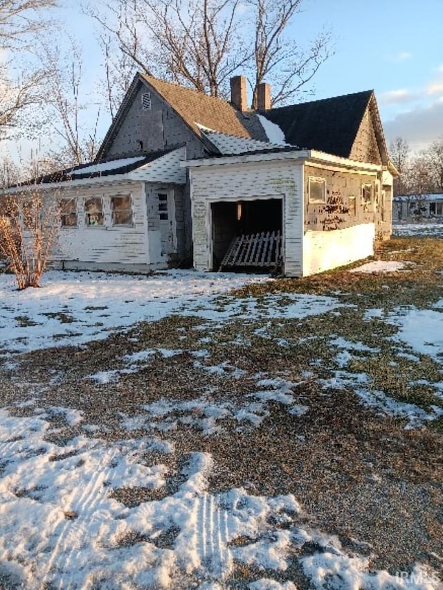 exterior space with an attached garage and a chimney