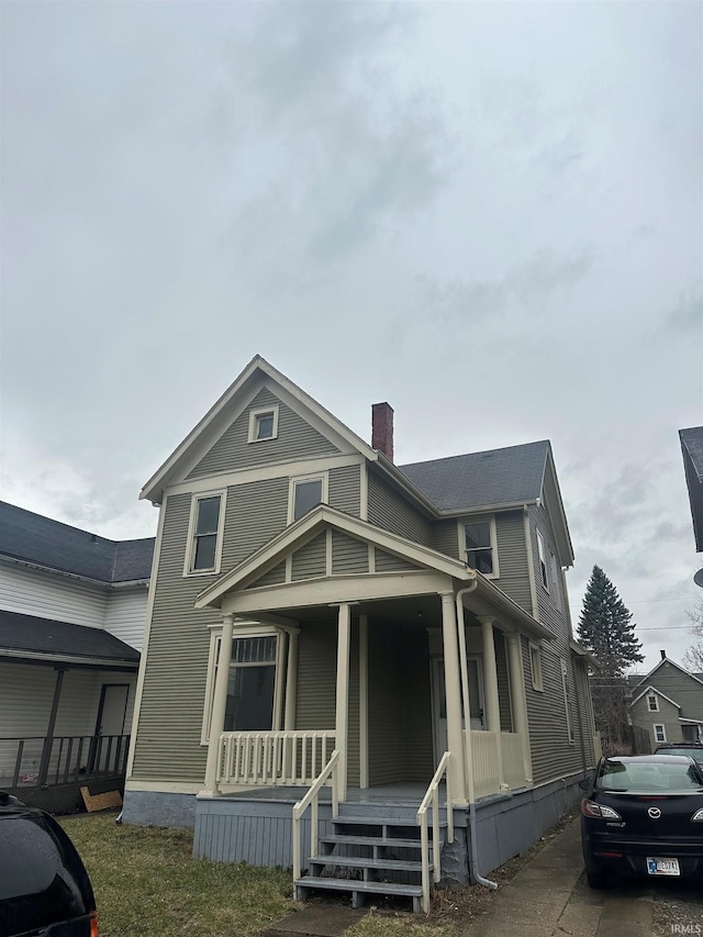 view of front of house with covered porch and a chimney