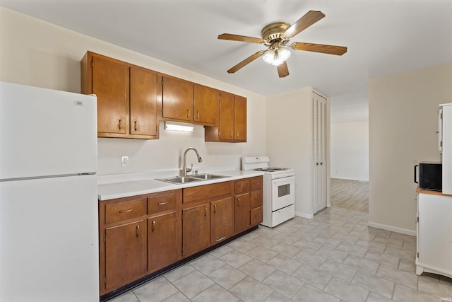 kitchen featuring a sink, white appliances, brown cabinetry, light countertops, and ceiling fan