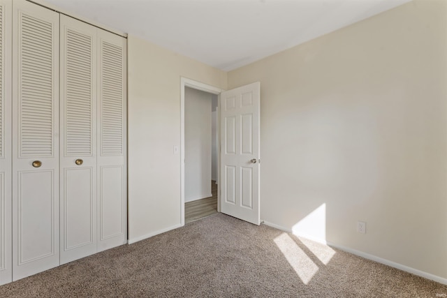 unfurnished bedroom featuring carpet flooring, baseboards, and a closet