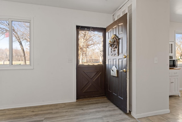 entryway with light wood-style floors and baseboards