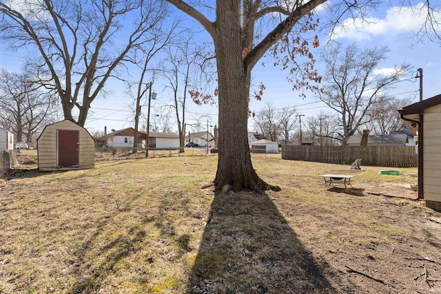 view of yard featuring an outdoor structure, a shed, and fence