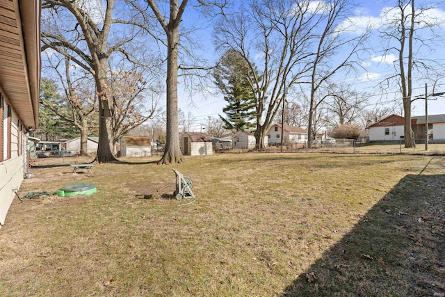 view of yard with a storage unit, an outdoor structure, and fence