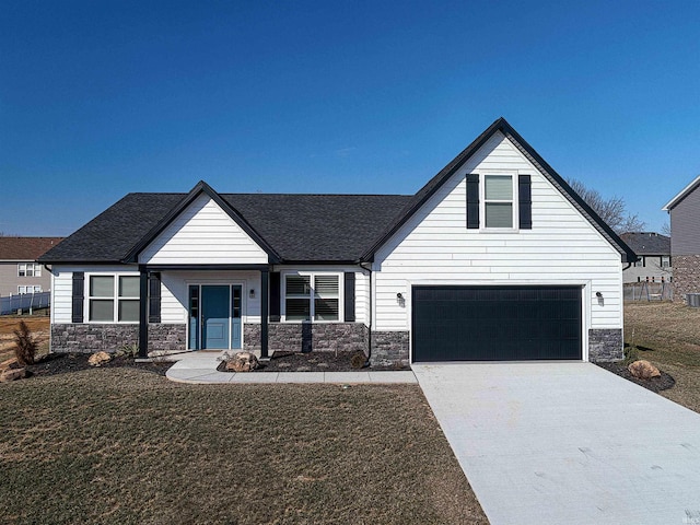 19138 Braeburn Dr, Evansville, IN 47725 - view of front facade featuring a front lawn, concrete driveway, roof with shingles, a garage, and stone siding