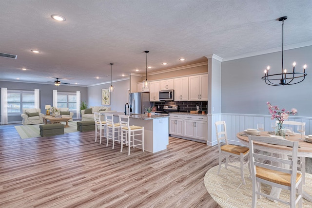 19138 Braeburn Dr, Evansville, IN 47725 - kitchen with visible vents, open floor plan, appliances with stainless steel finishes, white cabinets, and a kitchen island with sink