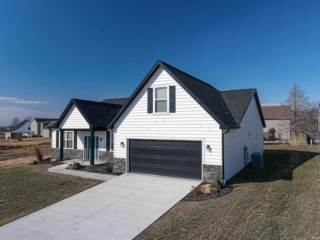 19138 Braeburn Dr, Evansville, IN 47725 - view of front of property with stone siding, central AC unit, concrete driveway, and a front lawn