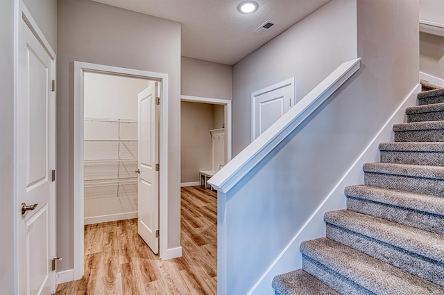 19138 Braeburn Dr, Evansville, IN 47725 - stairway featuring baseboards, wood finished floors, visible vents, and a textured ceiling