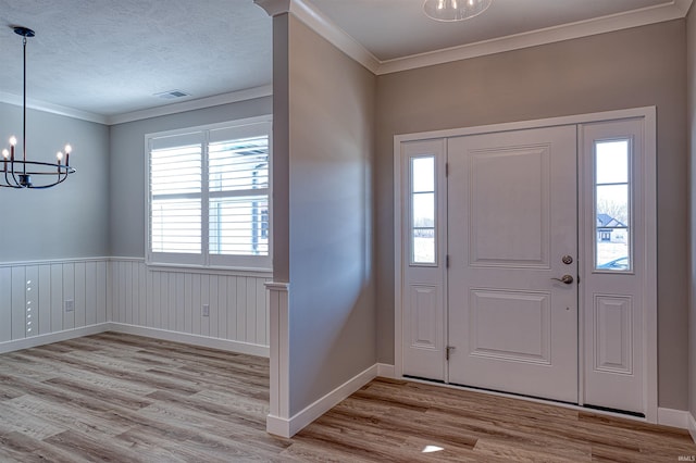 19138 Braeburn Dr, Evansville, IN 47725 - foyer entrance with an inviting chandelier, wood finished floors, visible vents, and ornamental molding