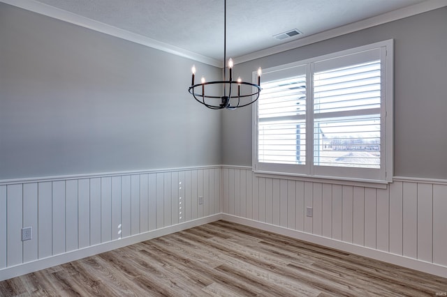 19138 Braeburn Dr, Evansville, IN 47725 - spare room with an inviting chandelier, wood finished floors, visible vents, and wainscoting
