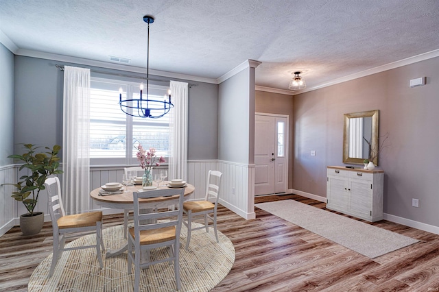 19138 Braeburn Dr, Evansville, IN 47725 - dining space featuring wood finished floors, visible vents, wainscoting, a textured ceiling, and a notable chandelier