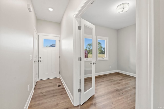 interior space with light wood finished floors, visible vents, and baseboards