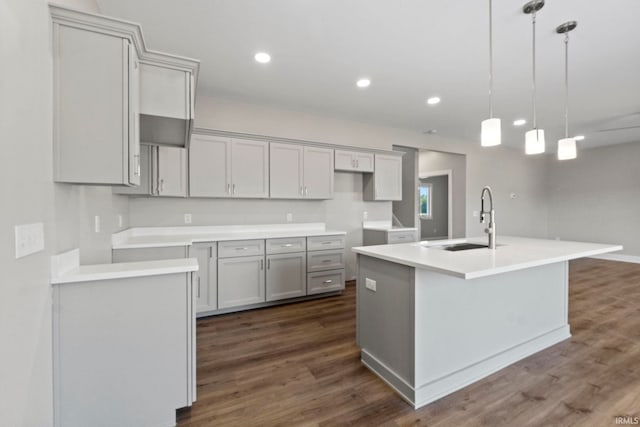 kitchen with a sink, dark wood-style floors, an island with sink, and recessed lighting