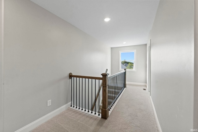 hallway with an upstairs landing, carpet flooring, recessed lighting, and baseboards