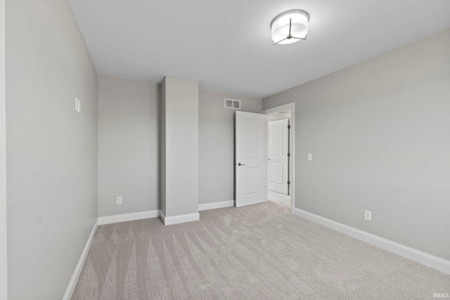 unfurnished bedroom featuring visible vents, carpet floors, and baseboards