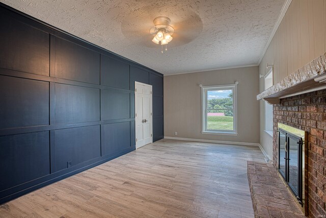 9700 Big Cynthiana Rd, Evansville, IN 47720 - unfurnished bedroom with light wood-style floors, a textured ceiling, crown molding, a brick fireplace, and a decorative wall