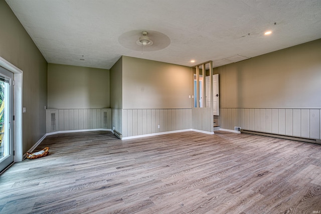 9700 Big Cynthiana Rd, Evansville, IN 47720 - empty room with baseboard heating, a wainscoted wall, and wood finished floors