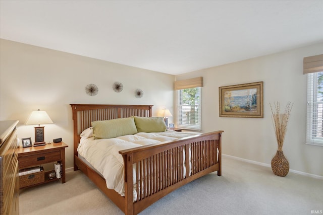 bedroom featuring baseboards and light colored carpet