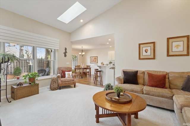 living room featuring baseboards, high vaulted ceiling, a skylight, recessed lighting, and a chandelier