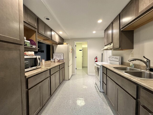316 N Main St, Churubusco, IN 46723 - kitchen featuring a sink, under cabinet range hood, recessed lighting, white appliances, and baseboards