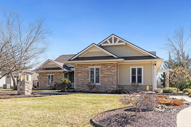 craftsman-style house with a front lawn, cooling unit, stone siding, and a shingled roof