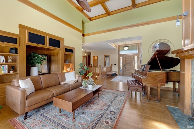 living area with beamed ceiling, coffered ceiling, a towering ceiling, and wood finished floors