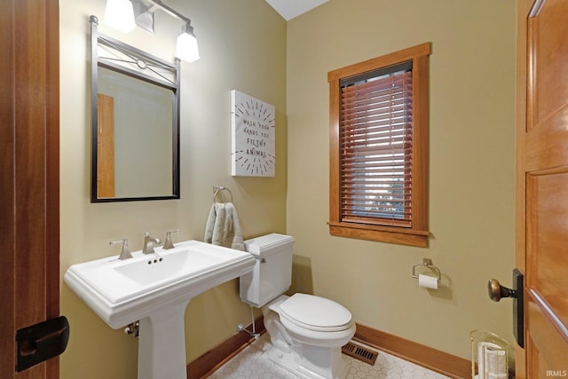 half bath with visible vents, toilet, and baseboards