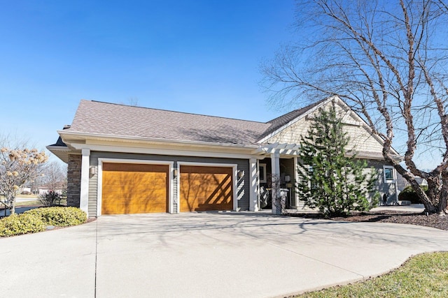 view of front of home featuring an attached garage, concrete driveway, and roof with shingles