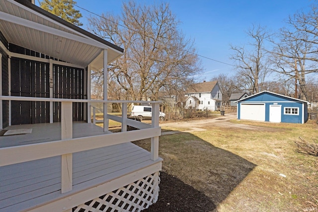 view of yard featuring an outbuilding, a detached garage, and a deck