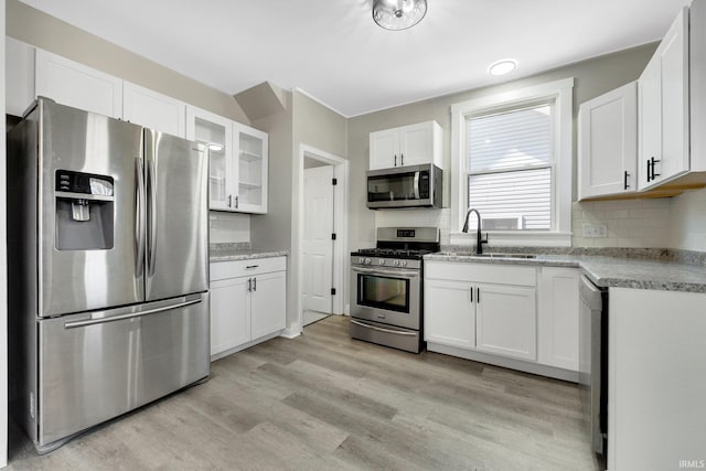kitchen with tasteful backsplash, appliances with stainless steel finishes, and a sink