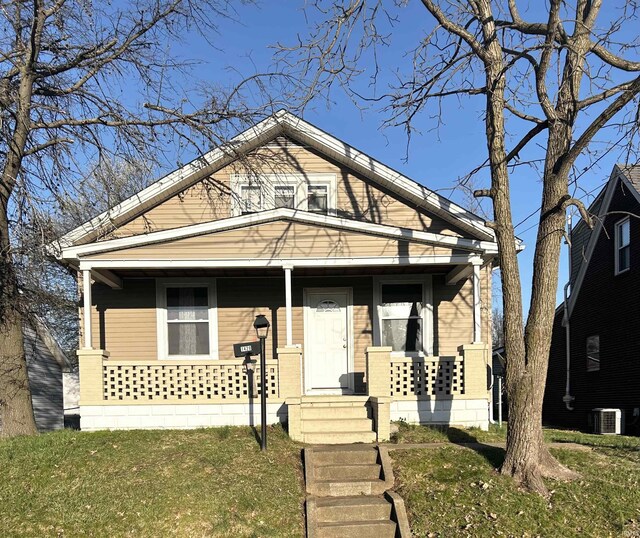 1428 11th St, Tell City, IN 47586 - bungalow with covered porch, cooling unit, and a front lawn