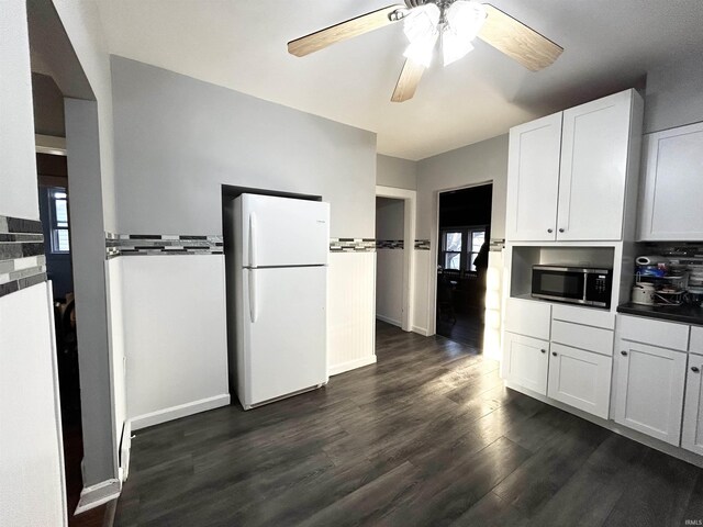 1428 11th St, Tell City, IN 47586 - kitchen featuring stainless steel microwave, freestanding refrigerator, dark wood-style floors, white cabinets, and a ceiling fan