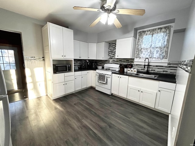 1428 11th St, Tell City, IN 47586 - kitchen featuring white electric range oven, dark wood finished floors, a sink, stainless steel microwave, and tasteful backsplash