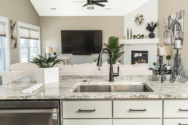 kitchen featuring visible vents, a sink, open floor plan, lofted ceiling, and ceiling fan