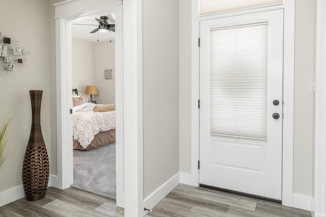 corridor with baseboards and light wood-style floors