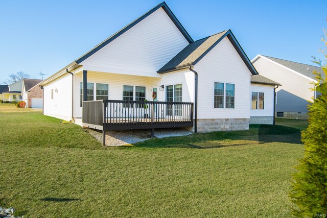 rear view of house featuring a lawn and a deck